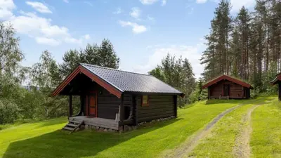 a small cabin in the middle of a green field at Skogcamping in Bjørnstad
