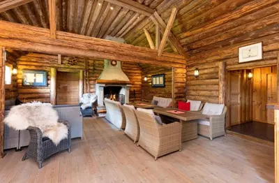 a dining room with a fireplace in a log cabin at Skogcamping in Bjørnstad