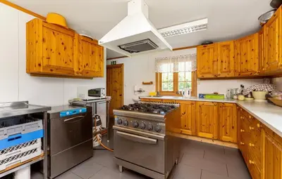 a kitchen with wooden cabinets and a stove top oven at Skogcamping in Bjørnstad