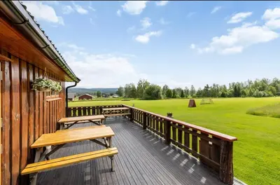 a deck with benches on the side of a building at Skogcamping in Bjørnstad