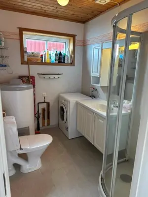 a bathroom with a sink and a washing machine at Vågen Fjordbuer - Sagbua in Ravlo