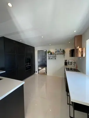a large kitchen with black cabinets and white counter tops at Unique apartment with fantastic views in Bergen