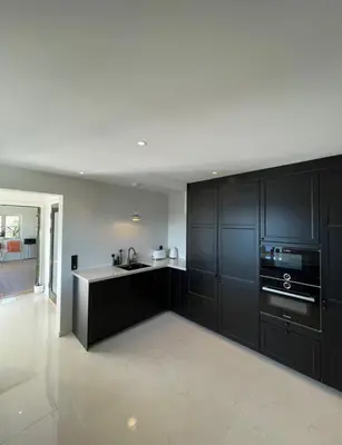 a kitchen with black cabinets and a black appliances at Unique apartment with fantastic views in Bergen