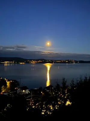 a full moon rising over a lake at night at Villa with a view in Morviki