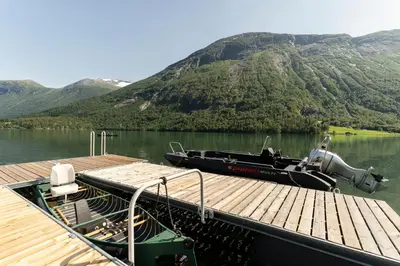 a boat is docked at a dock on a lake at Stryn Golden Resort - Panorama I in Stryn