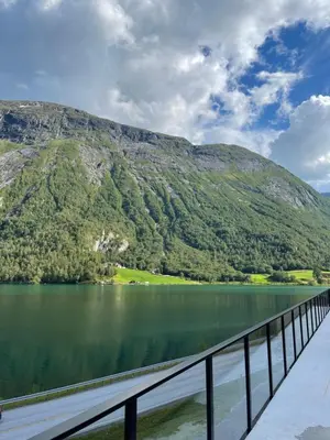 a bridge over a lake with mountains in the background at Stryn Golden Resort - Panorama II in Stryn