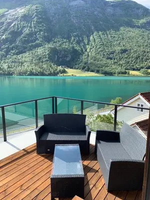a deck with two chairs and a table and a lake at Stryn Golden Resort - Panorama II in Stryn