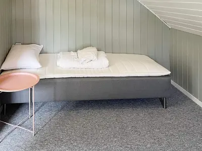 a bed in a room with a small table and a bed sidx sidx at 6 person holiday home in BØMLO in Bømlo