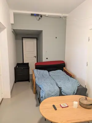 a small bedroom with two beds and a table at Liten leilighet midt i sentrum in Stryn