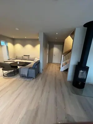 a living room with a couch and a table and a fireplace at Nytt hus i fredfullt nabolag in Verdal