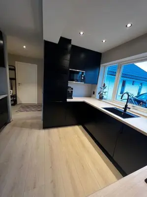 a kitchen with black cabinets and a sink and a window at Nytt hus i fredfullt nabolag in Verdal
