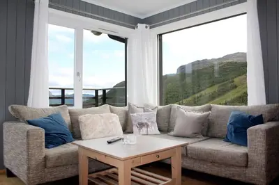 a living room with a couch and a large window at Hemsedal, Ski in Ski out, Skarsnuten Panorama 55 in Tuv