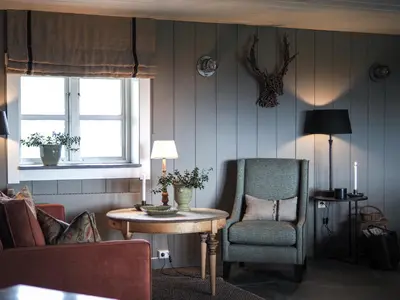 a living room with a table and a chair at Danebu Kongsgaard - Boutique Hotel in Aurdal