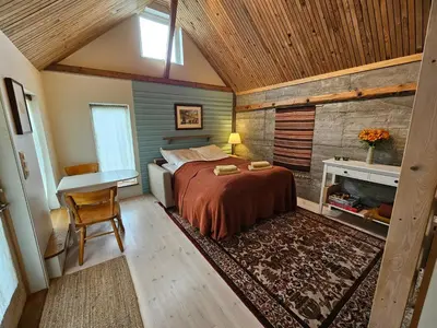 a bedroom with a bed and a desk and a table at Sigurd's Tiny House in Vossevangen