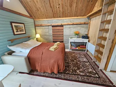 a bedroom with a bed in a room with a fireplace at Sigurd's Tiny House in Vossevangen