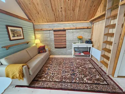 a living room with a couch and a rug at Sigurd's Tiny House in Vossevangen