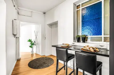 a kitchen with a table and chairs and a window at 3-Bedroom - Heart of Trondheim Center in Trondheim