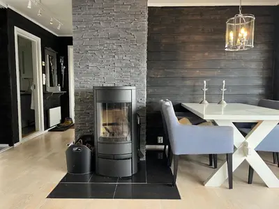 a fireplace in a living room next to a dining table at Cozy apt with a view in Beitostøl
