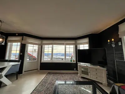 a living room with a tv and a large window at Cozy apt with a view in Beitostøl