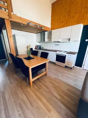 a kitchen and dining room with a wooden table and chairs at Leilighet med særpreg in Lillehammer