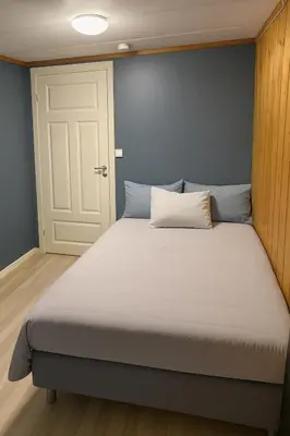 a large bed in a room with a white door at Leilighet med særpreg in Lillehammer