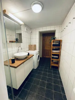 a bathroom with a sink and a washing machine at Leilighet med særpreg in Lillehammer