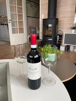 a bottle of wine and two glasses on a table at Modern, lovely holidayhome, in quiet nature close to Trolltunga in Utsikten
