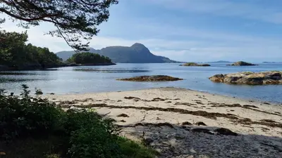 a view of a beach with rocks in the water at Utsikten in Korsnes