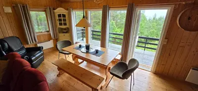 a living room with a table and chairs and a couch at Utsikten in Korsnes