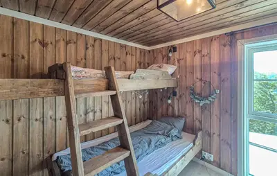 a room with two bunk beds in a wooden wall at Awesome Home In Norheimsund With Wifi in Norheimsund