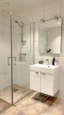 a bathroom with a white sink and a shower at Magical view towards the fjords by the sea in Ålesund