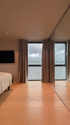 a bedroom with a view of the ocean from a mirror at Magical view towards the fjords by the sea in Ålesund