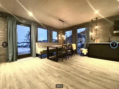 a dining room with a table and some windows at Fjellhytte med ski inn-ut in Torvetjørn