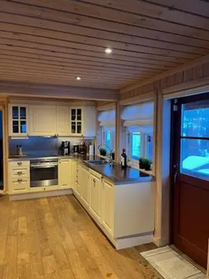 a kitchen with white cabinets and a wooden ceiling at Hytte Gaustablikk in Gaustablikk