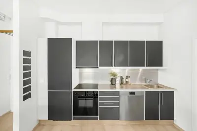 a kitchen with stainless steel cabinets and a sink at Sentral 2-romsleilighet in Trondheim