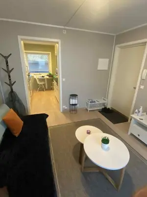 a living room with a couch and a table at Sentralt leilighet in Ålesund