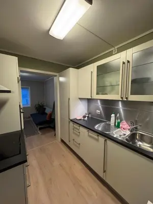 a kitchen with white cabinets and a sink at Sentralt leilighet in Ålesund