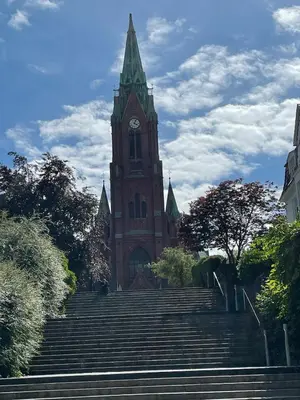 a building with a clock tower with stairs in front at Flott leilighet in Bergen