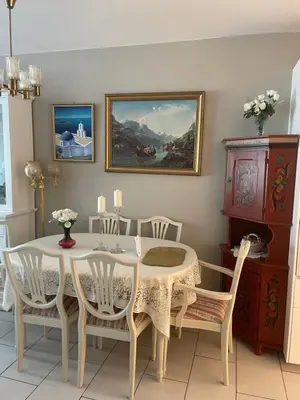 a dining room with a white table and chairs at Flott leilighet in Bergen