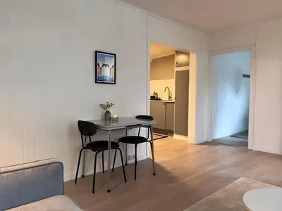 a living room with a table and two chairs at Koselig leilighet i Ålesund sentrum in Ålesund