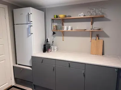 a kitchen with a refrigerator and a counter top at Koselig leilighet i Ålesund sentrum in Ålesund