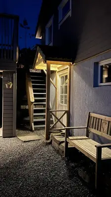 a wooden bench sitting outside of a house with a door at Shelby's Home in Heimstad