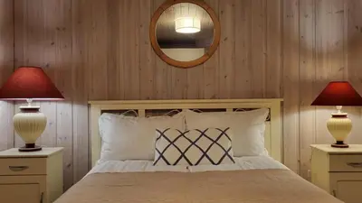 a bedroom with a bed with two lamps and a mirror at Shelby's Home in Heimstad