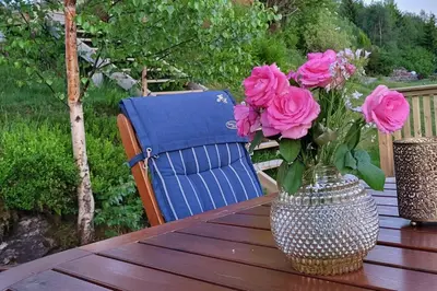 a vase of flowers sitting on a table with a chair at Shelby's Home in Heimstad