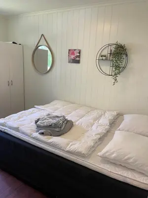 a large bed in the corner of a room at Fjordhus in Austerheim