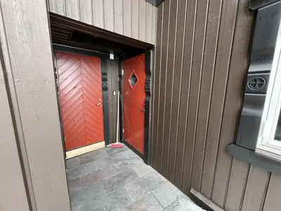 a doorway to a building with two red doors at Cozy Apartment With Stunning Mountain Views in Beitostøl