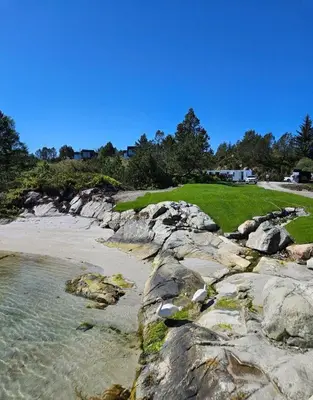 a view of a beach with rocks and the ocean at Eksklusiv hytte i skjærgården! in Austevoll