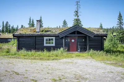 a cabin with a red door and a grass roof at Trysilfjellet Nord 356 C in Trysil