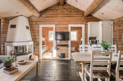 a living room with a table and a fireplace at Trysilfjellet Nord 356 C in Trysil
