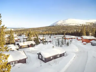 a village covered in snow with a mountain in the background at Trysilfjellet Nord 356 C in Trysil